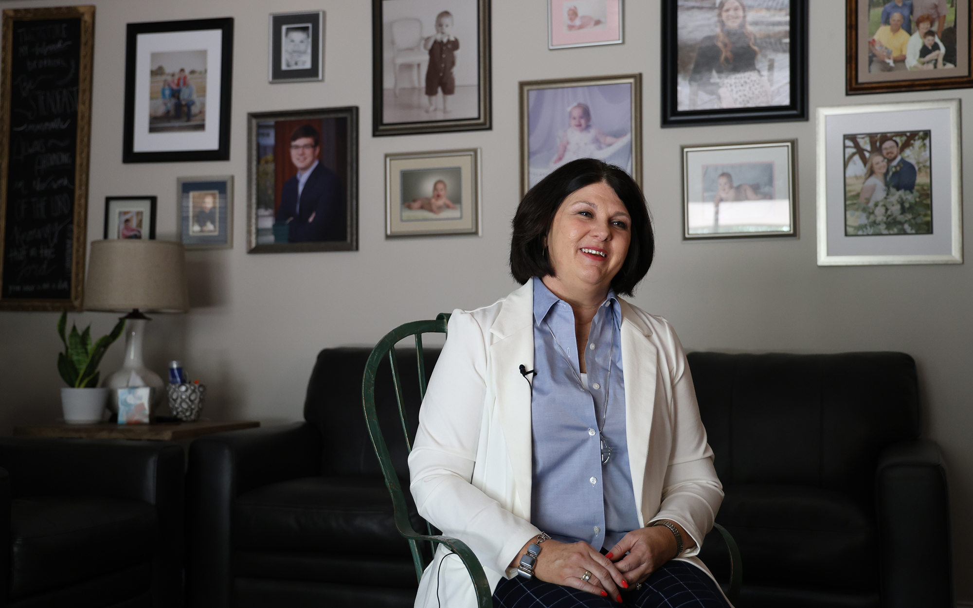 Lori Bova, an anti-abortion activist, sits in her living room against a backdrop of family photos in Hobbs, New Mexico, on June 25, 2023. Bova has been instrumental in the effort to get some New Mexico towns to pass local ordinances against abortion. (Photo by Cassidey Kavathas/News21)
