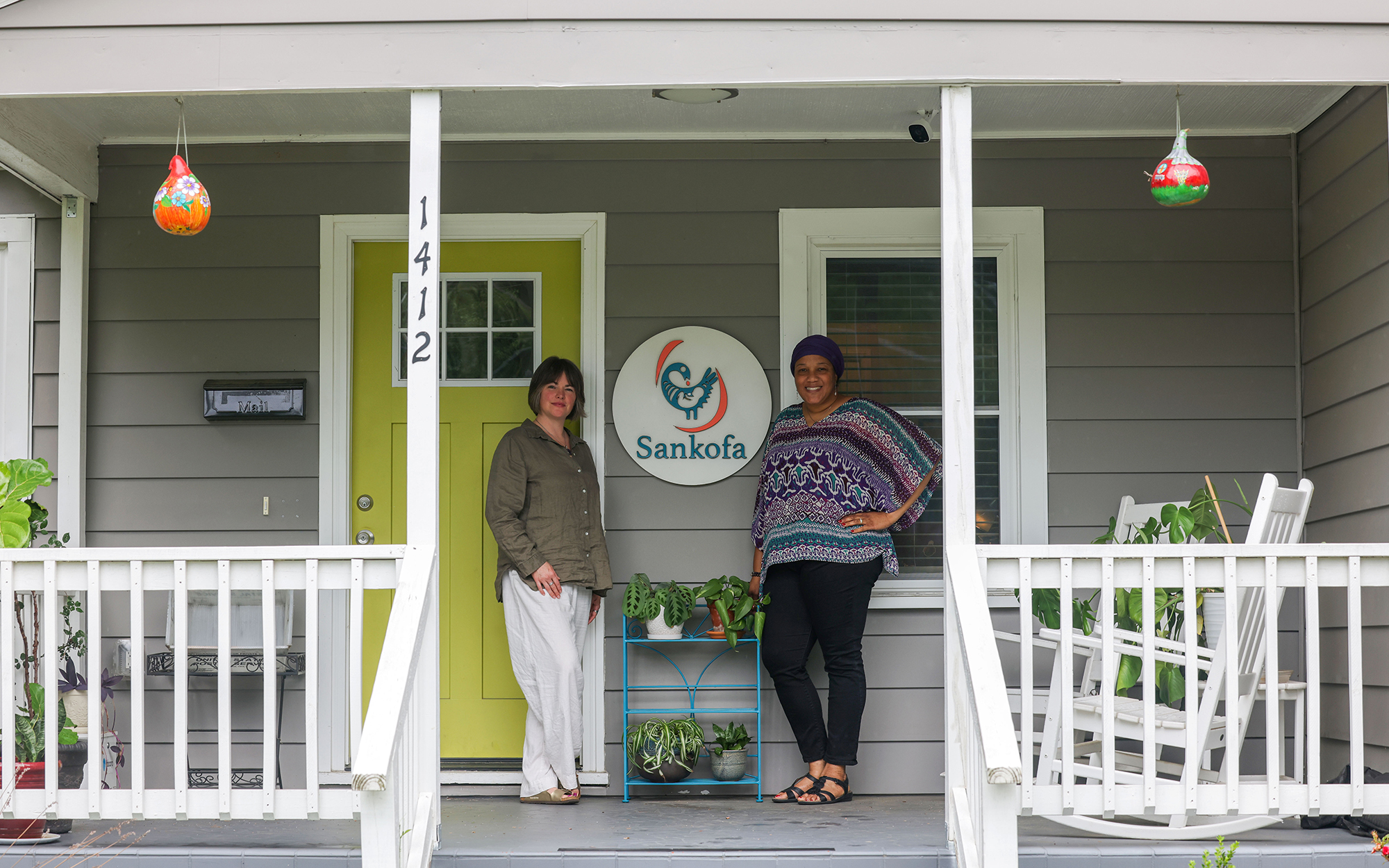 Amber Rodriguez, left, and Tina Braimah pose on the porch of Sankofa Birth and Women’s Center, which is located within a neighborhood to ensure it is accessible to the community. (Photo by Shelby Rae Wills/News21)