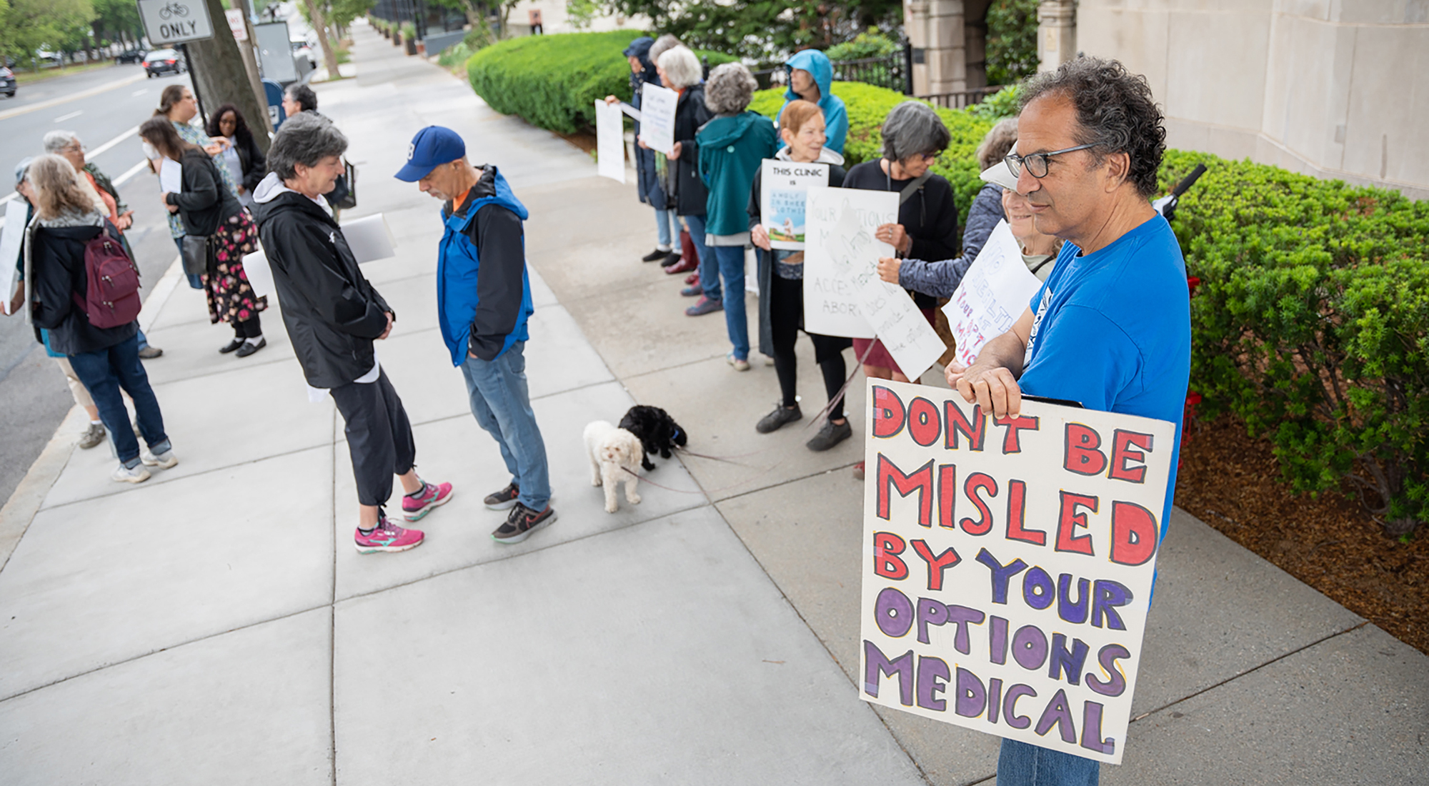 Protesters with Indivisible Mass Coalition hold signs outside the so-called “crisis pregnancy center,” Your Options Medical, in Brookline, Massachusetts, on June 17, 2023. (Photo by Mingson Lau/News21)