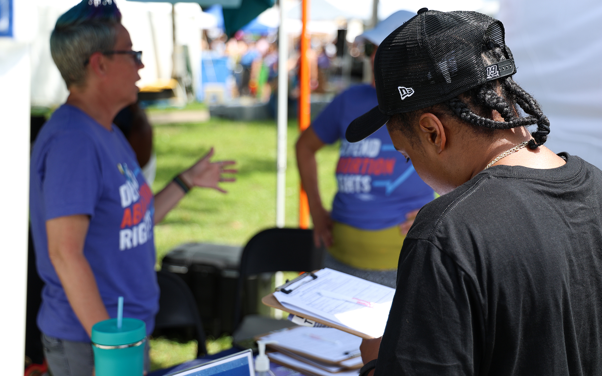 Amber Holman, right, signs a petition for the proposed “Right to Reproductive Freedom” amendment at a community festival in Columbus on June 25, 2023. In November, Ohio voters will decide whether to enshrine abortion rights in the state constitution. (Photo by Maddy Keyes/ News21)