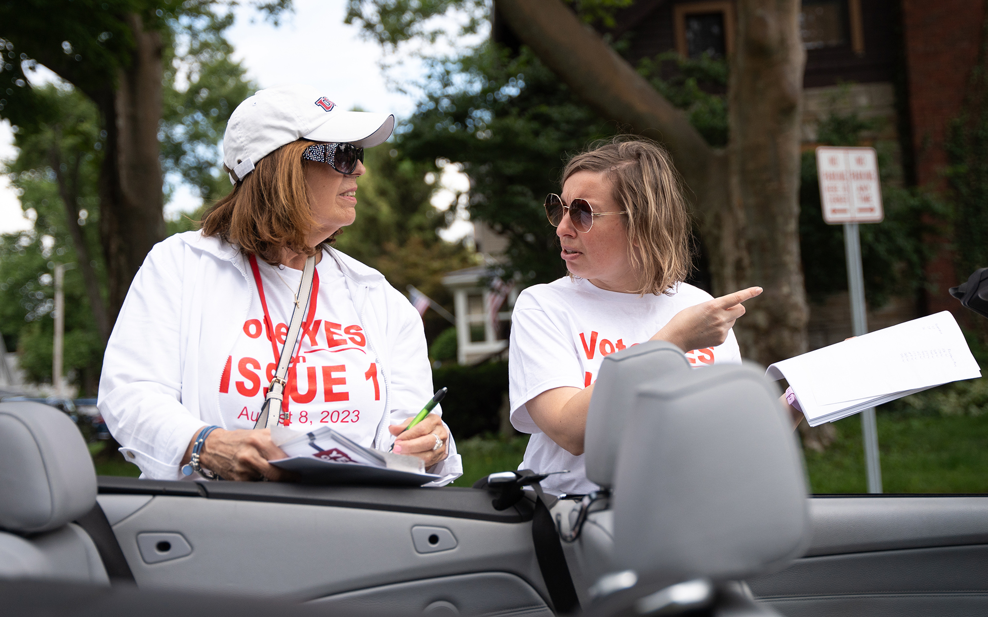 Kristine Wolfe, left, a Delaware County precinct committeewoman, and Janine Baker, president of the Delaware City Republican Club, plan their route as they go door to door on June 24, 2023, to urge people to vote “yes” on State Issue 1. (Photo by Mingson Lau/News21)